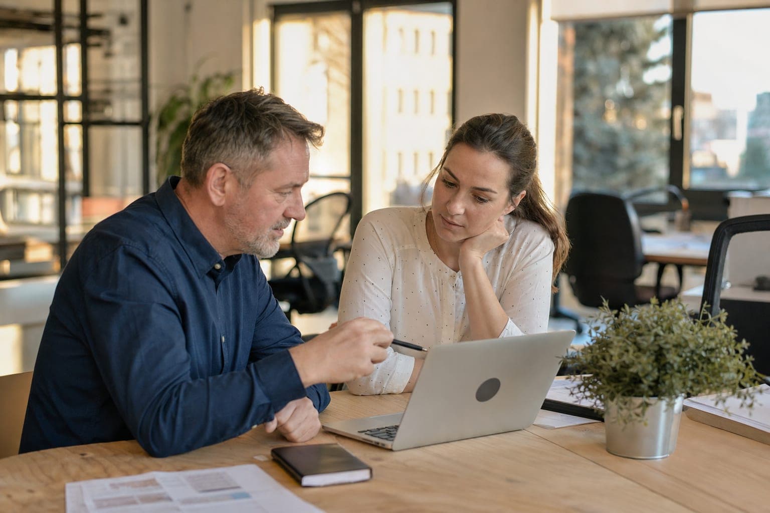 Zwei Personen im Büro besprechen am Laptop die offene Stelle